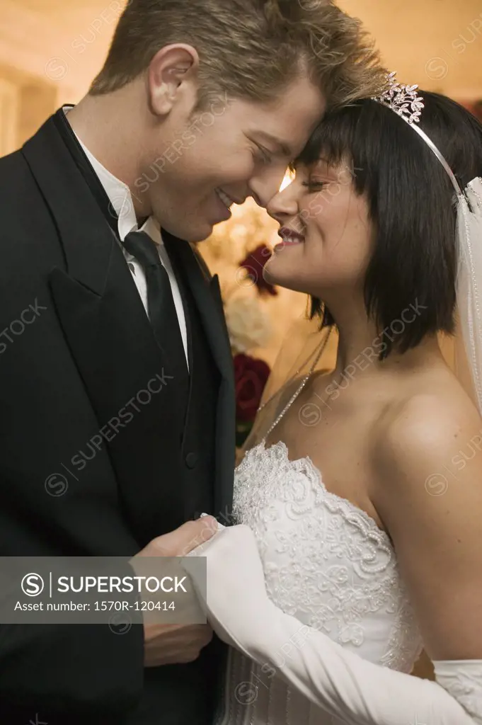 Bride and groom standing face to face at an altar