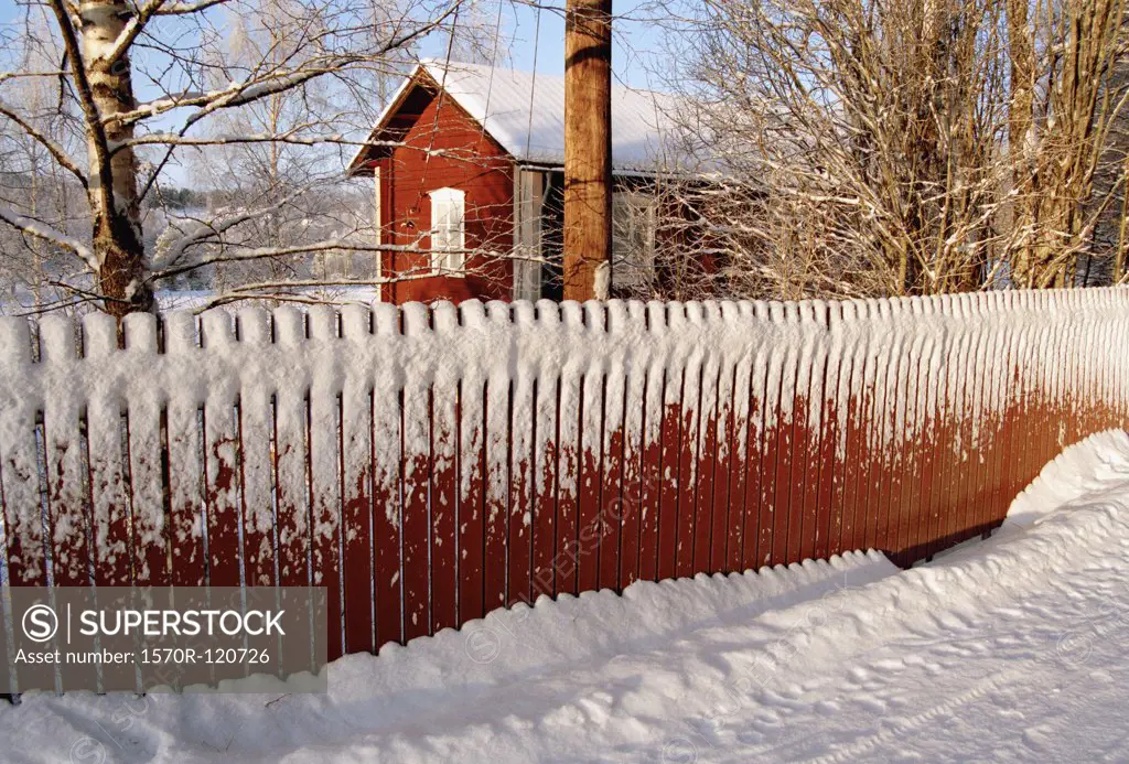 Snow-capped house behind a picket fence, Sweden