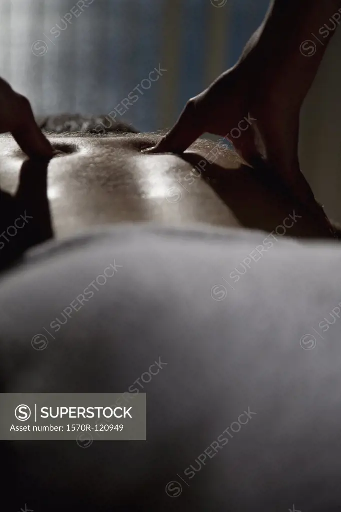 Close-up of a woman massaging a man's back
