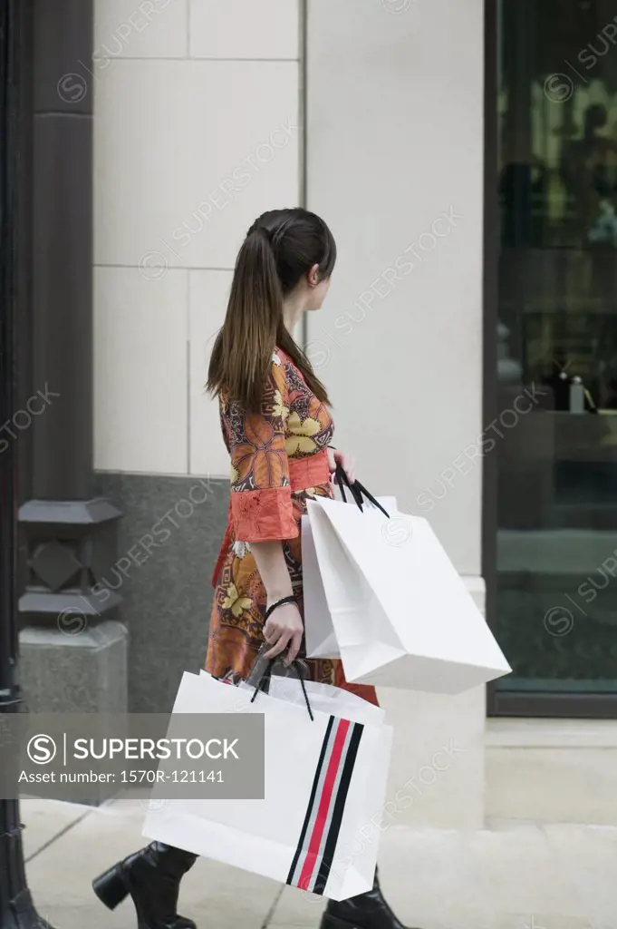 A woman walking down the street with shopping bags, Rodeo Drive, Los Angeles, California