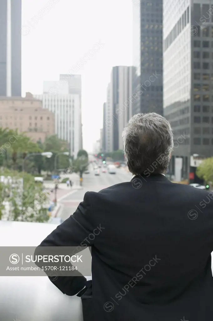 Businessman standing on a balcony in the financial district