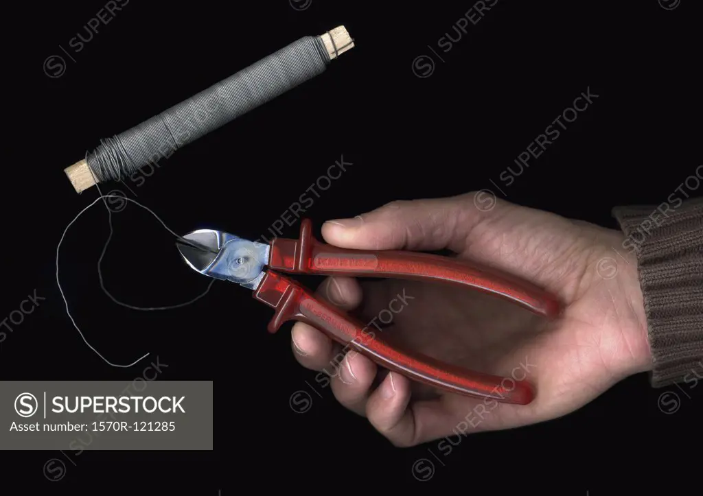 Man cutting wire with pliers