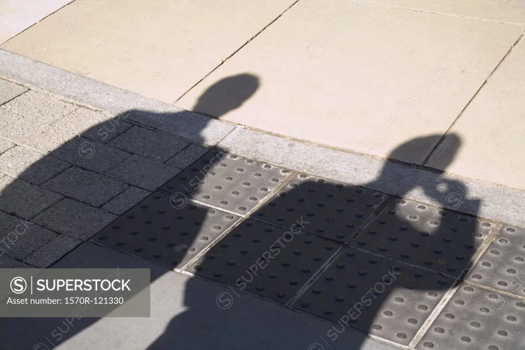 Shadow of two businessmen on the pavement