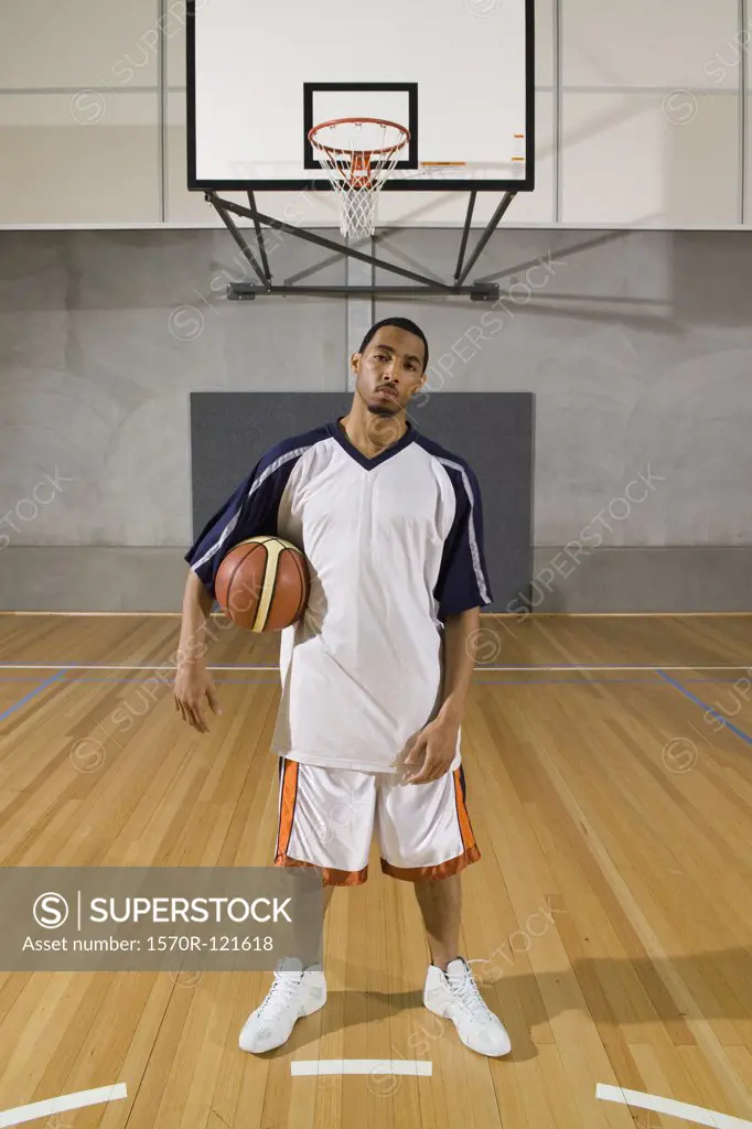 A young man standing on a basketball court with a basketball