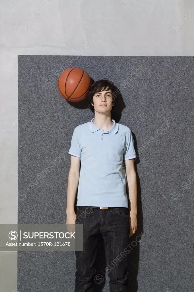 A man standing with a basketball by his head