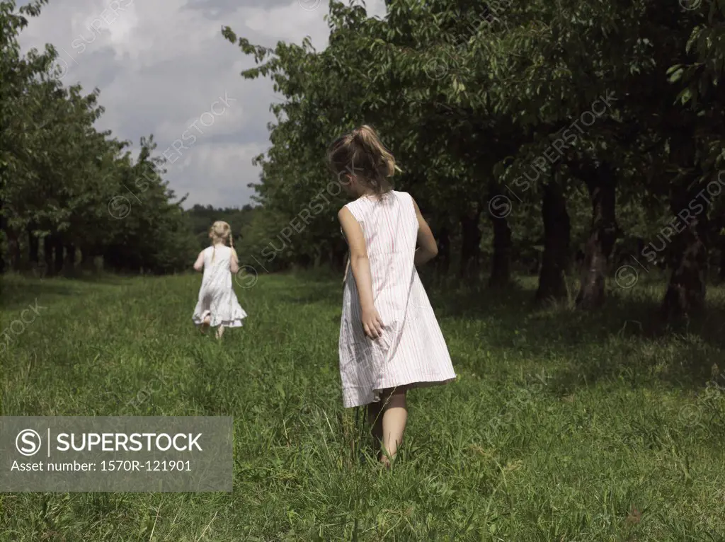 Two girls walking through a field
