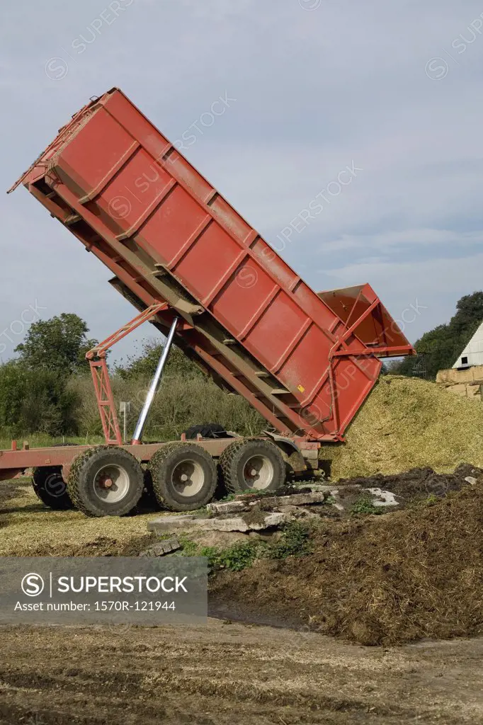 Dump truck emptying manure into a field