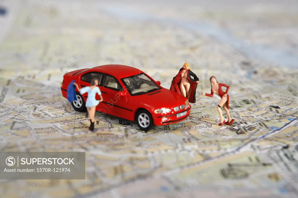 Women of the night figurines posed around a toy car on top of a road map