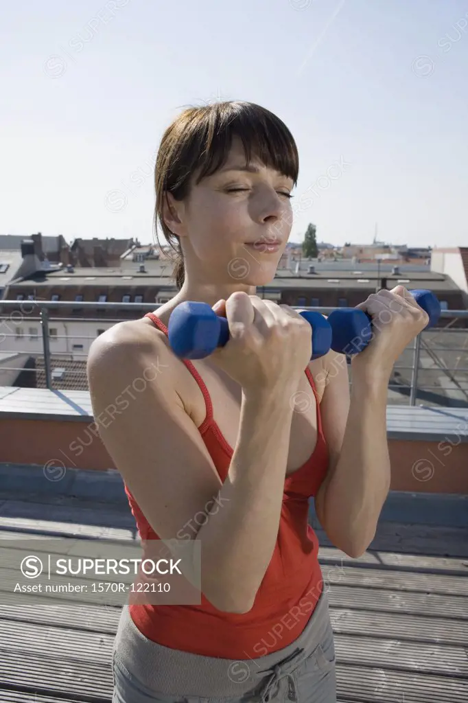 A woman weightlifting on a terrace
