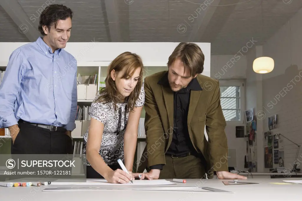 Three people brainstorming in an office