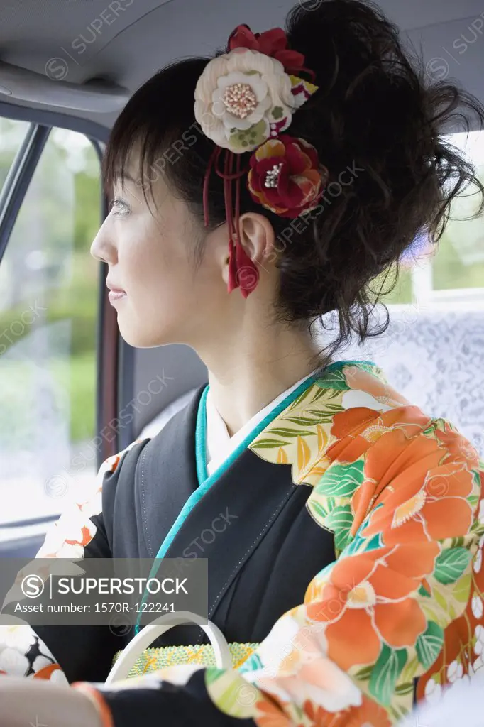 A woman wearing a kimono inside a car