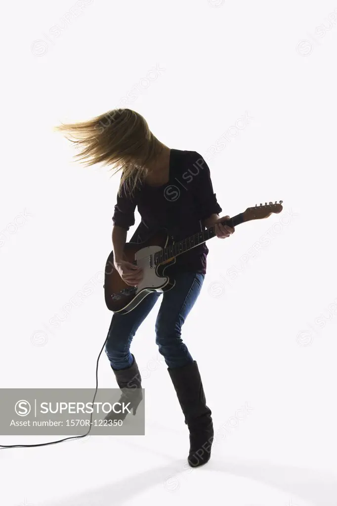 Studio shot of a woman playing an electric guitar