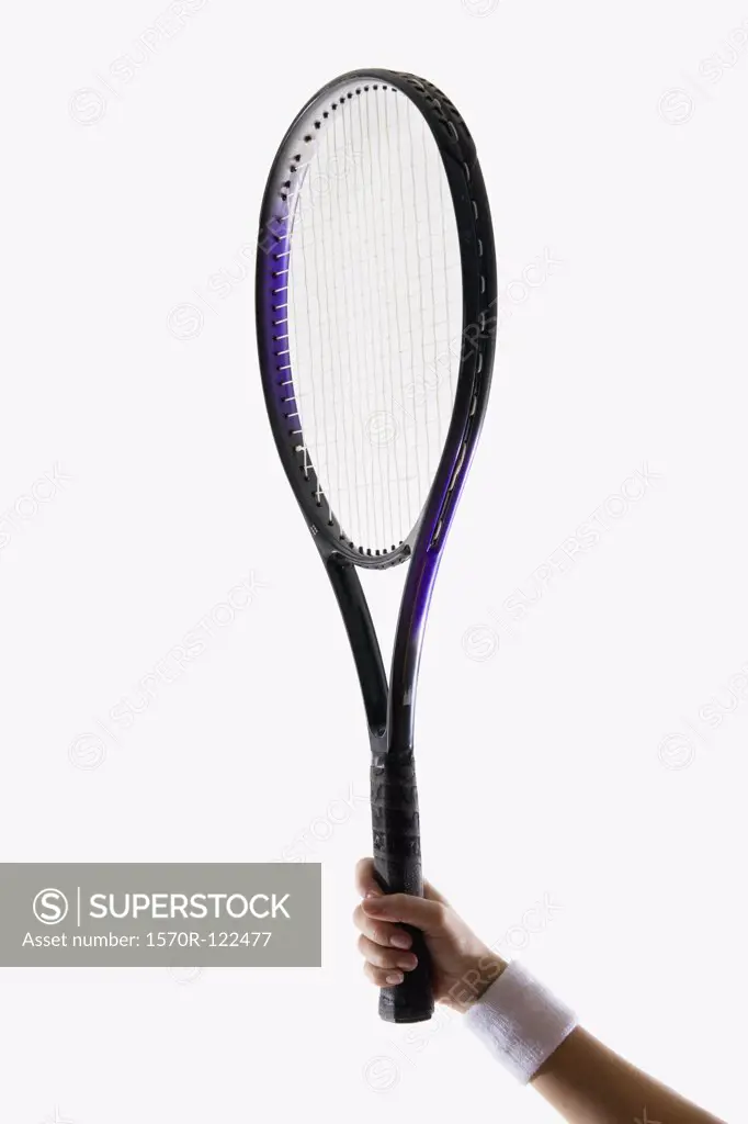 A human arm holding a tennis racket up