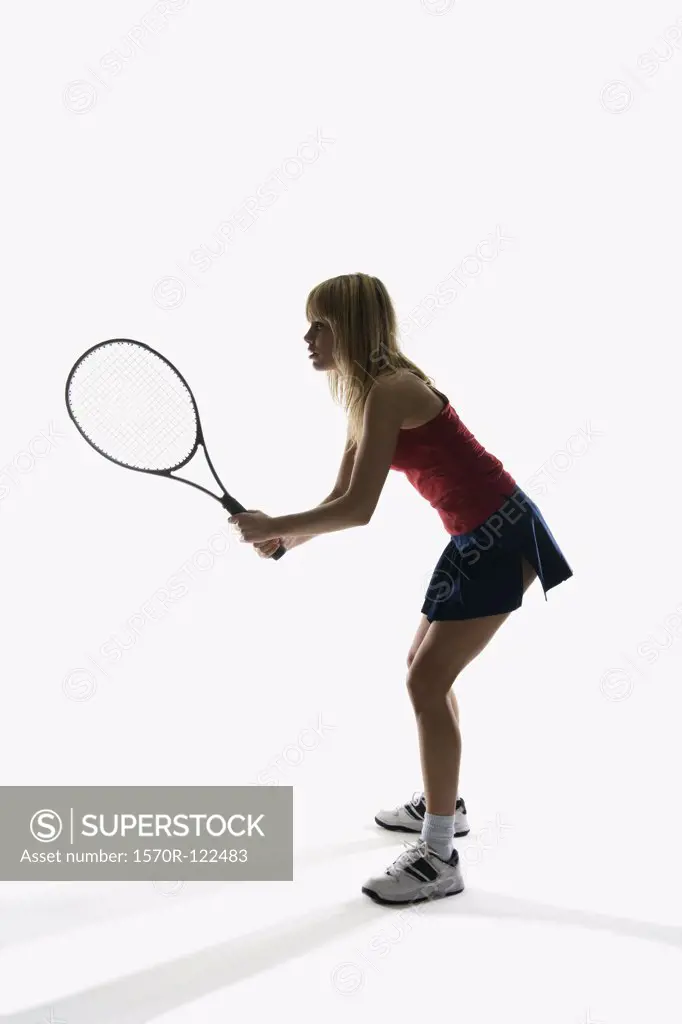 Studio portrait of a female tennis player holding a tennis racket