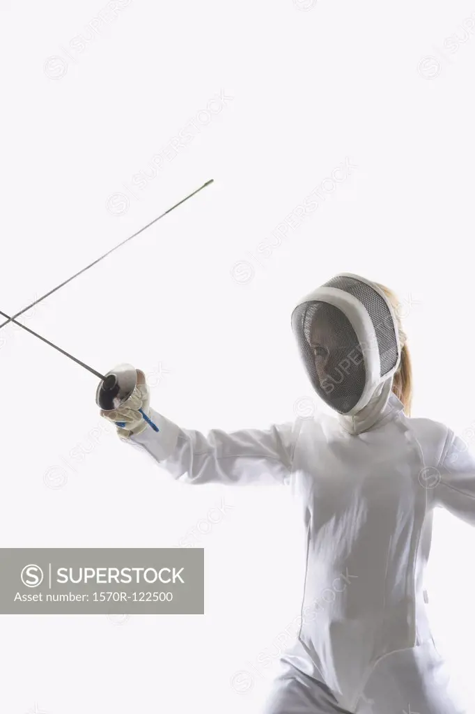 Studio shot of female fencer posing with a fencing foil in a confrontation with another fencing foil