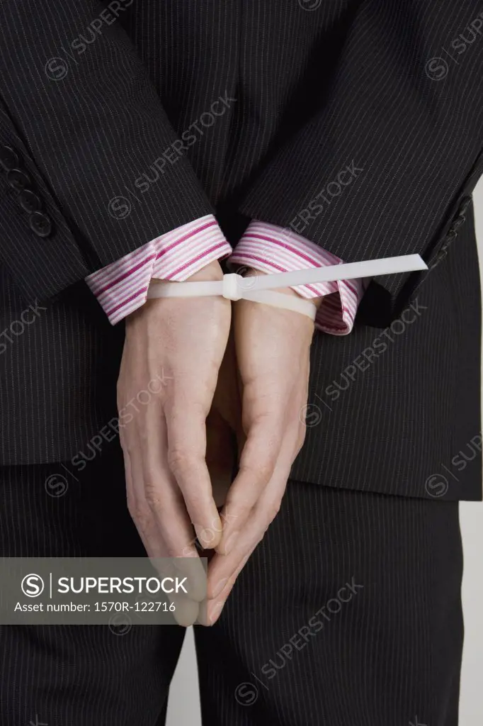 A businessman with his hands tied behind his back