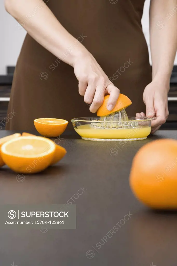 A woman juicing oranges