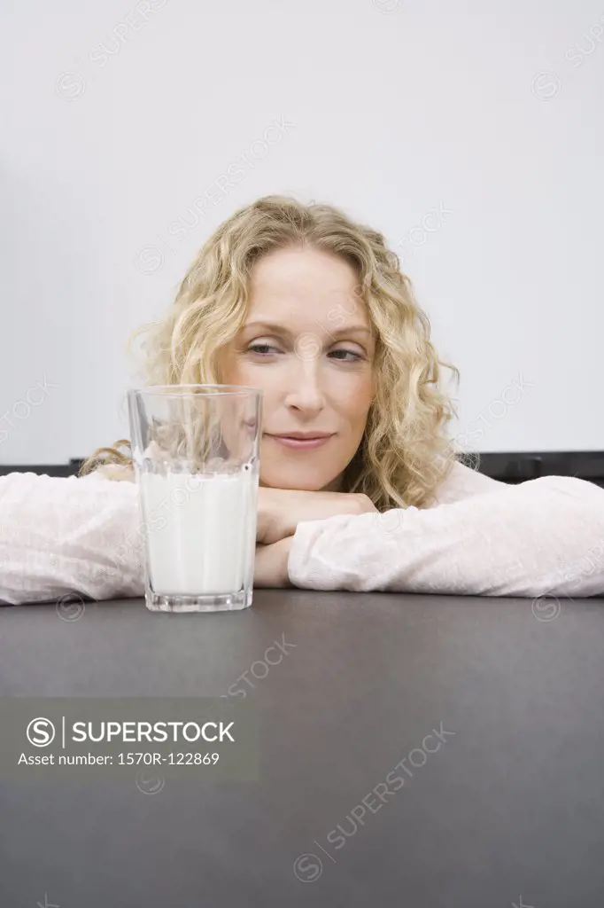A woman looking at a glass of milk