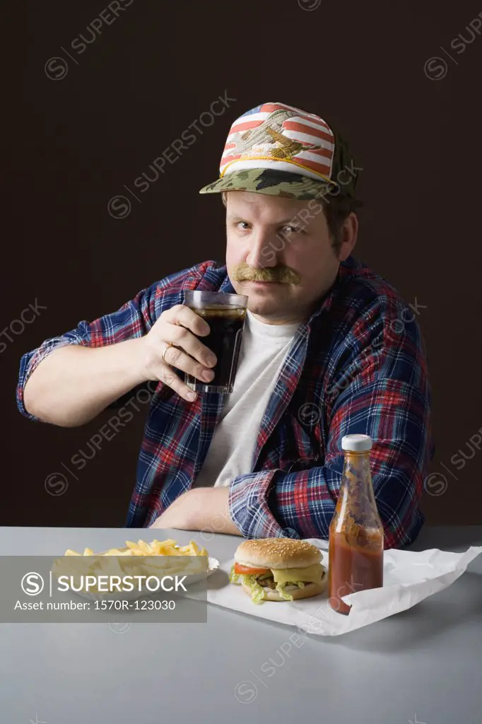 Stereotypical American man with burger, fries and a cola