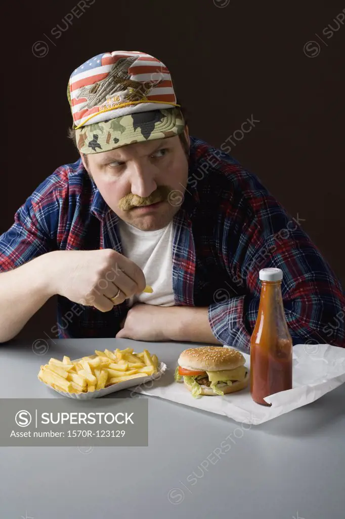 Stereotypical American man eating a fast food meal