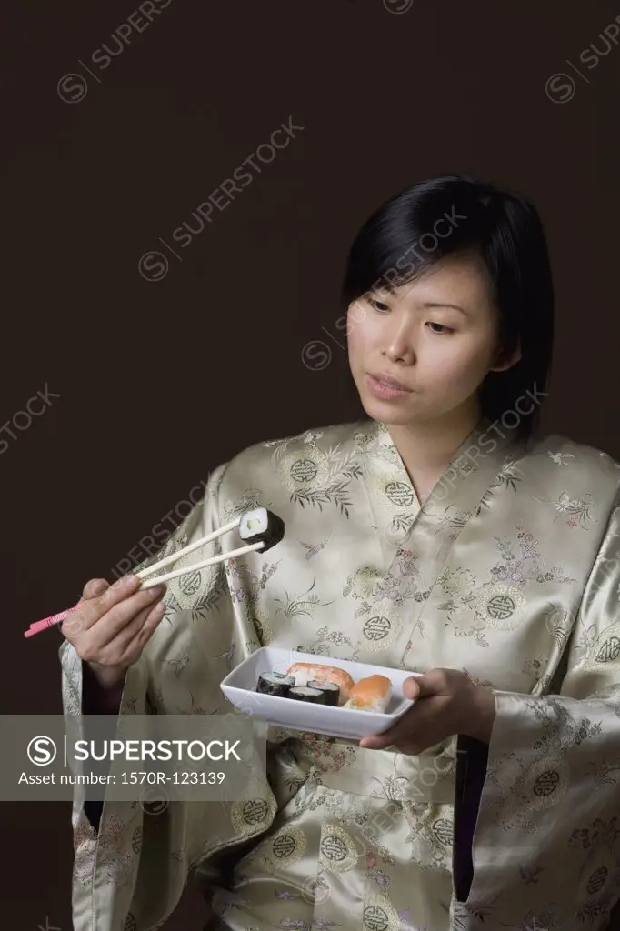 A woman dressed in a kimono eating sushi