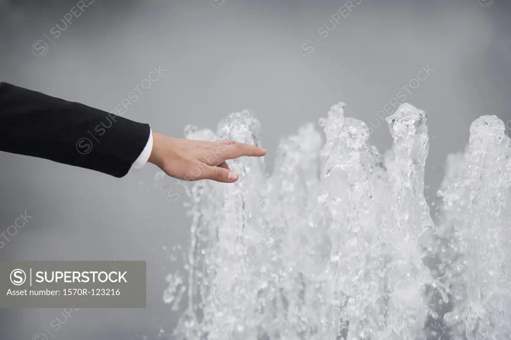 A hand reaching to a fountain