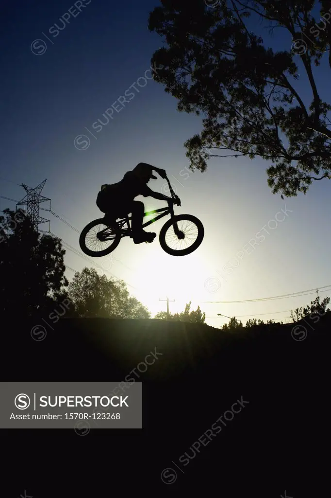 Silhouette of a person doing a stunt on a BMX bicycle