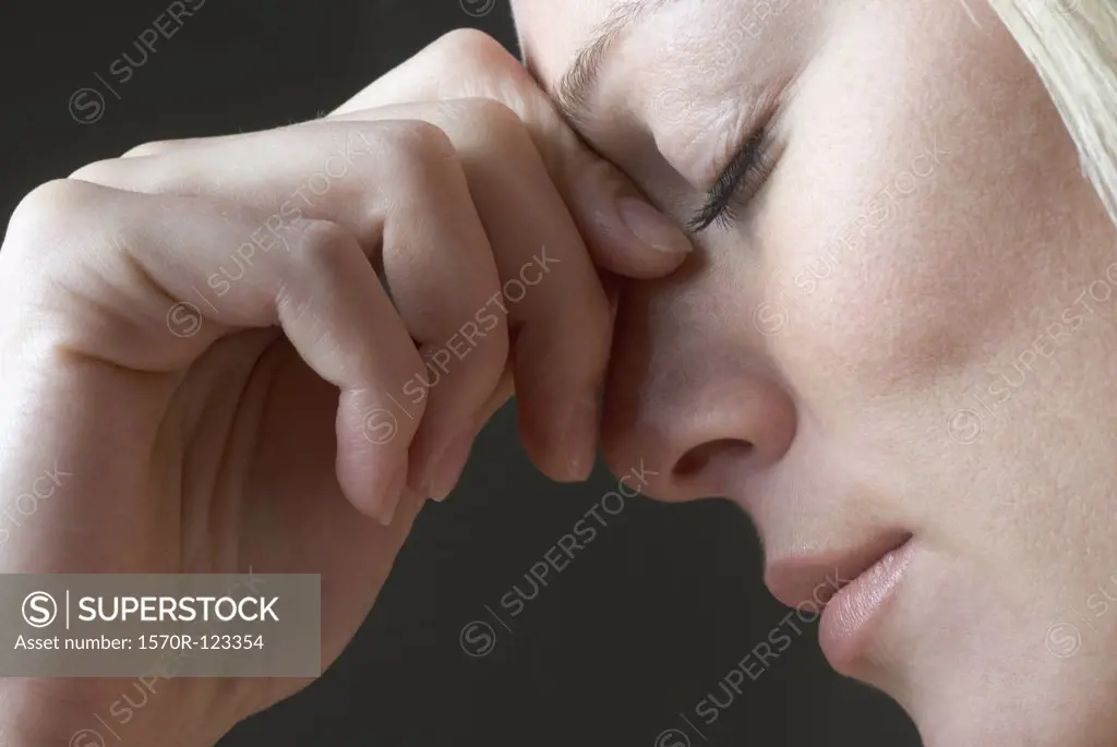 A woman squeezing the bridge of her nose