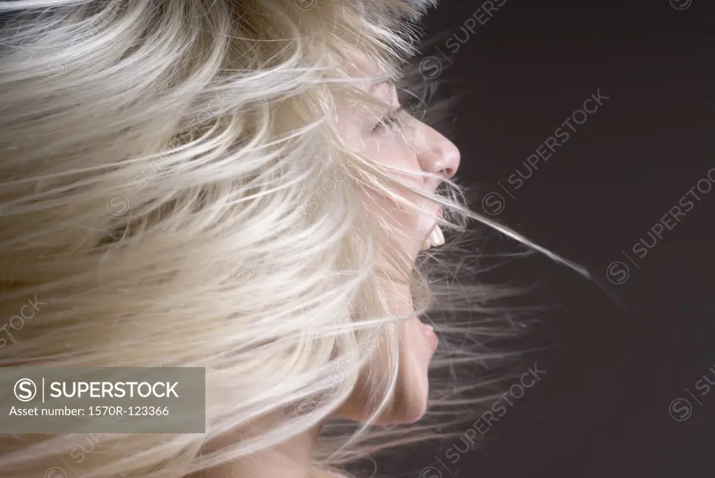 A woman tossing her hair with her mouth open