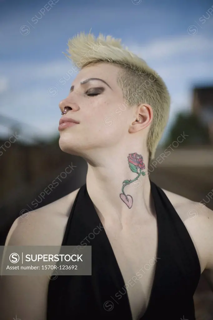 Profile of a young woman with a mohawk holding her head back