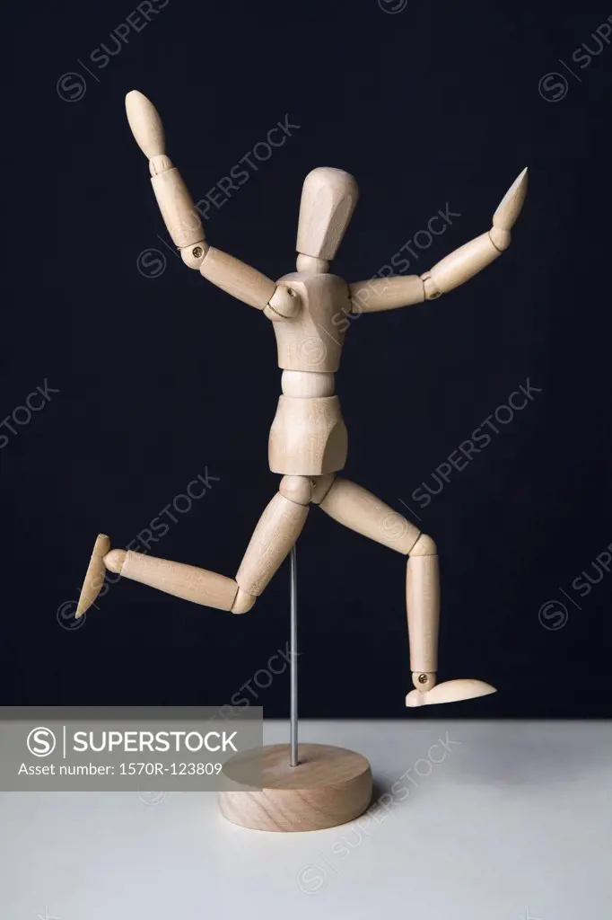 Artist's figure running with arms raised