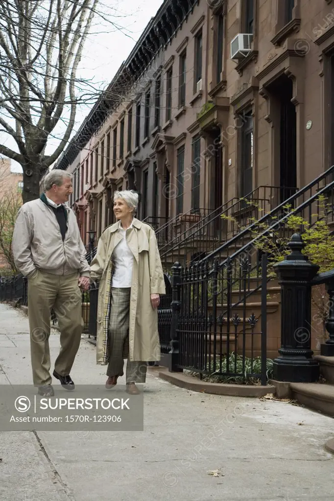 A senior couple walking on a city sidewalk