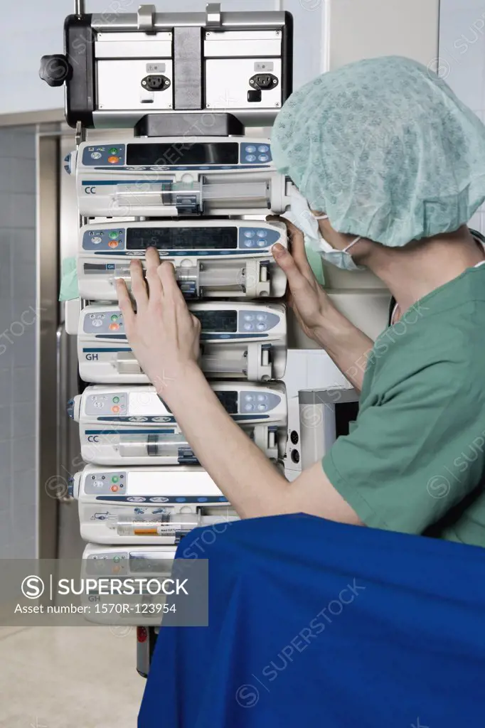 A healthcare worker adjusting a medical machine