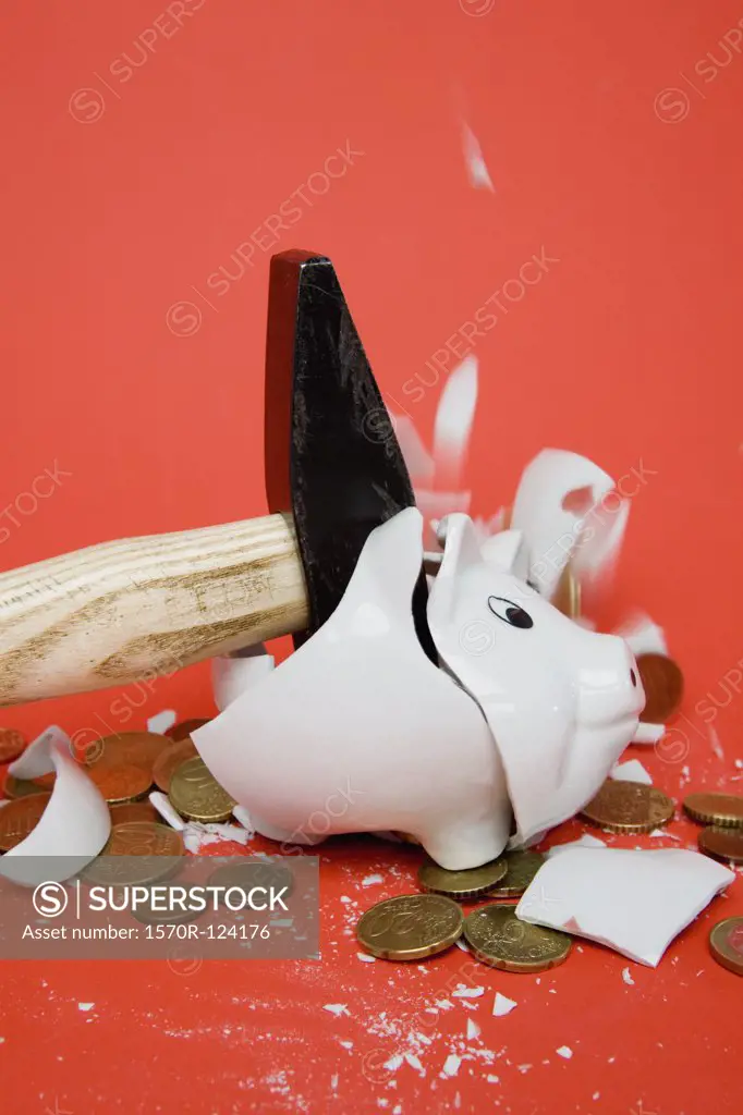 A hammer smashing a piggy bank