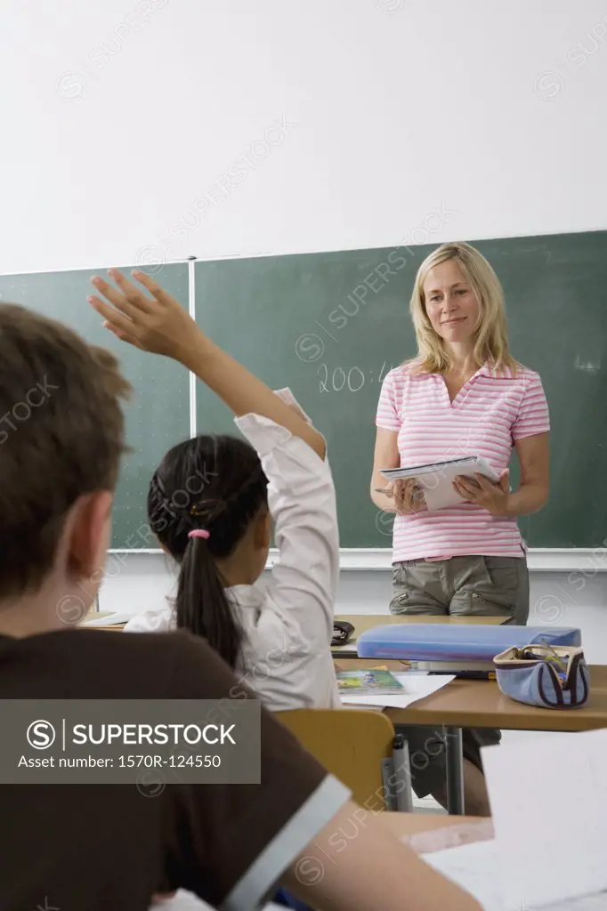 A teacher teaching a class, over the shoulder view