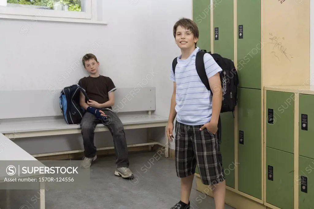 Two pre-adolescent boys relaxing in a locker bay