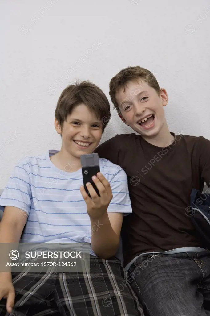 Two pre-adolescent boys looking at a mobile phone