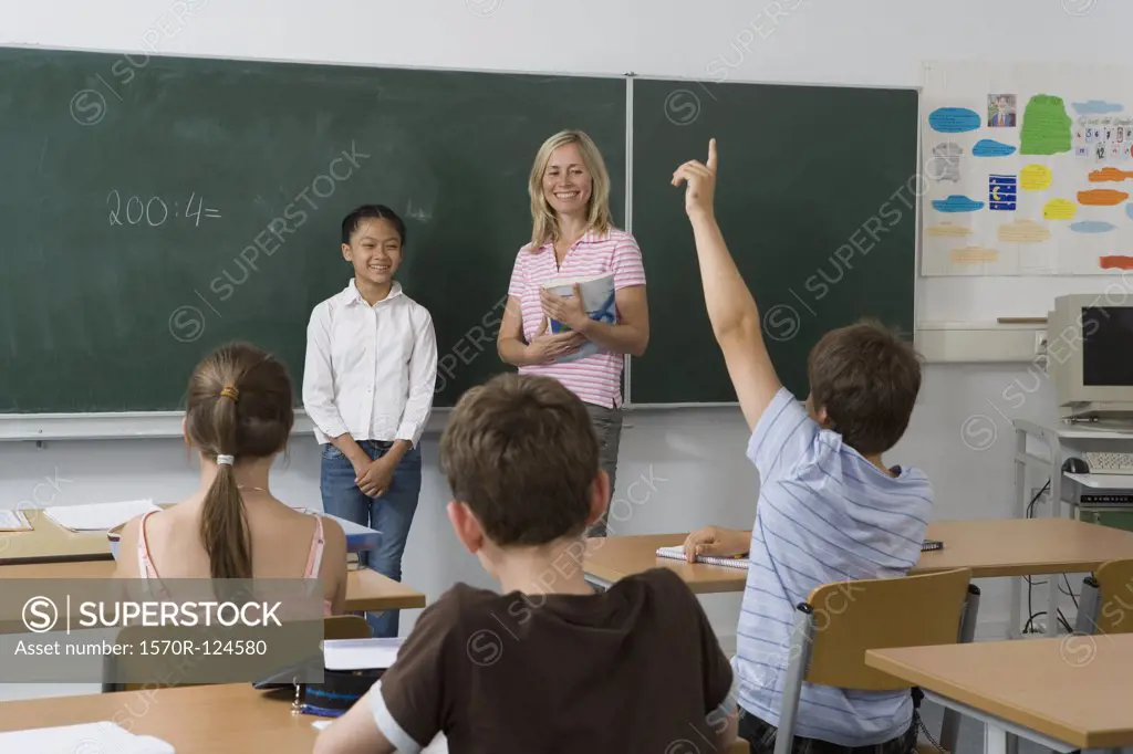 A teacher and a student at the blackboard, facing the class