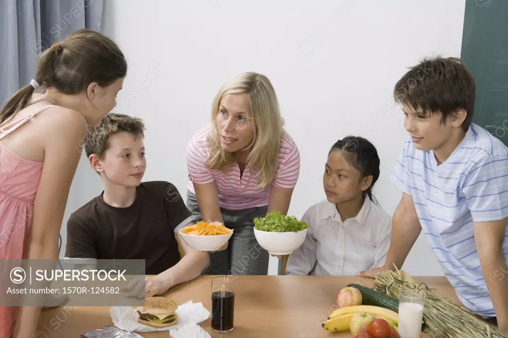 A teacher and four students learning about nutrition