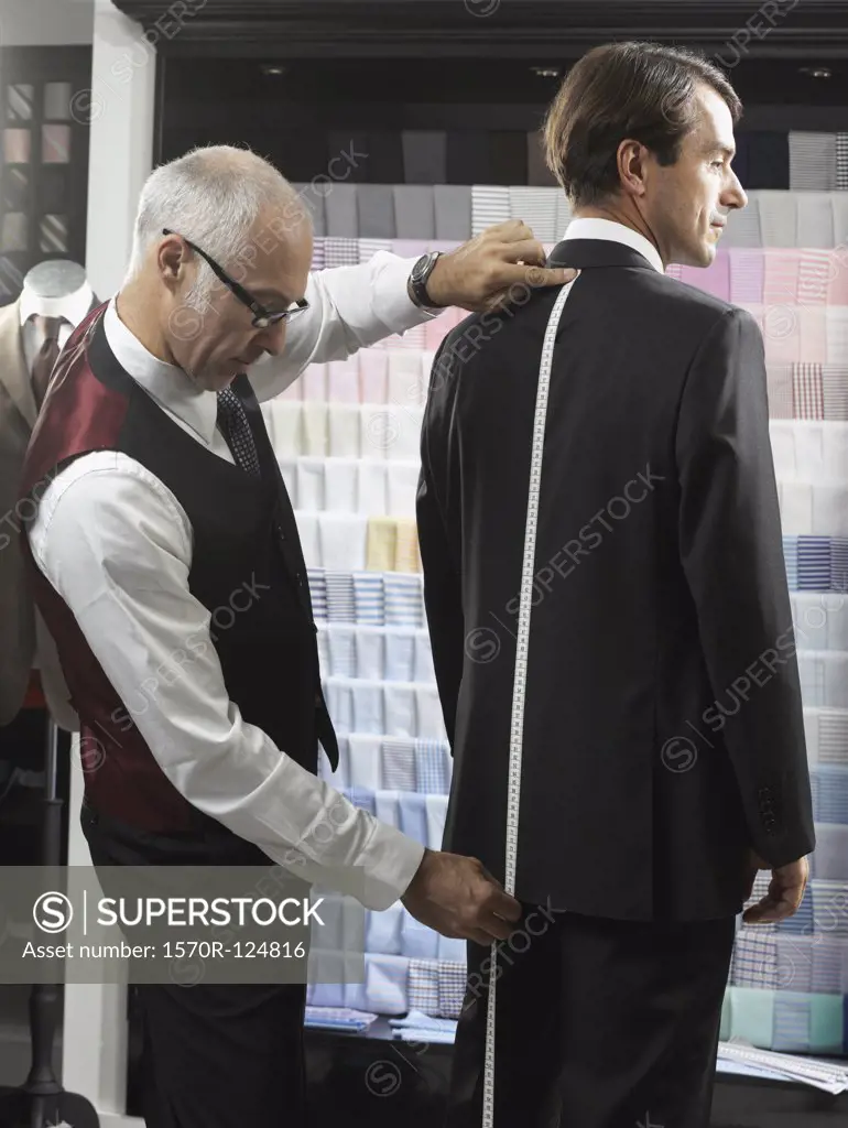 A tailor fitting a man with a suit