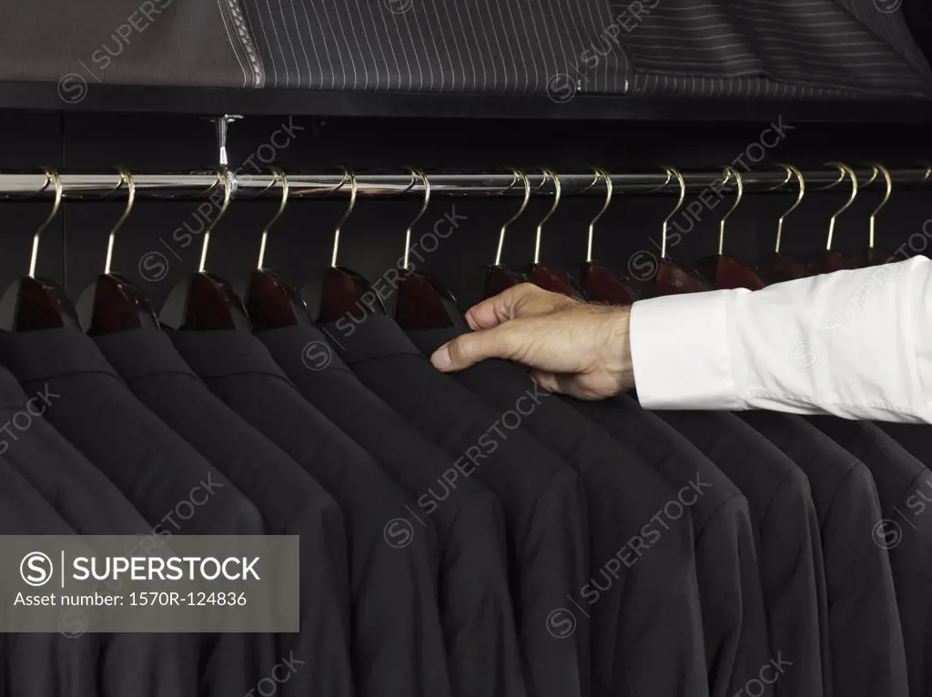 A man selecting a jacket from a clothing rack