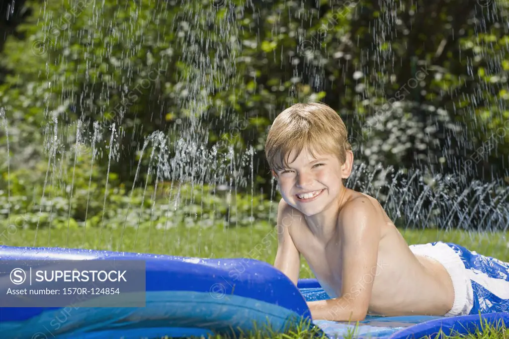 A boy lying on a water slide