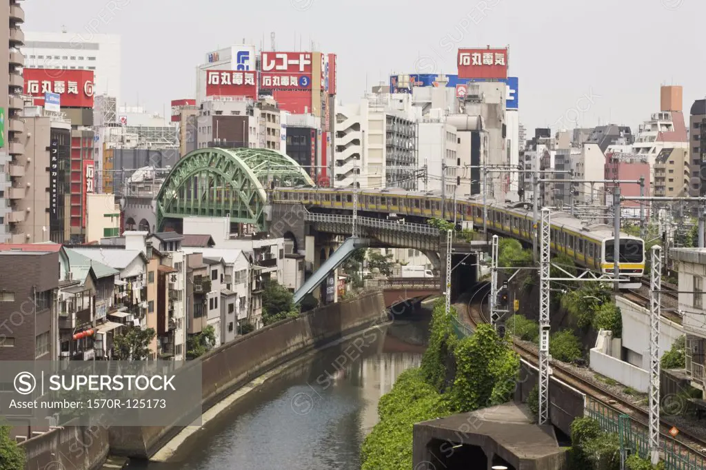 Train crossing the Kanda River with Akihabara district in background, Tokyo