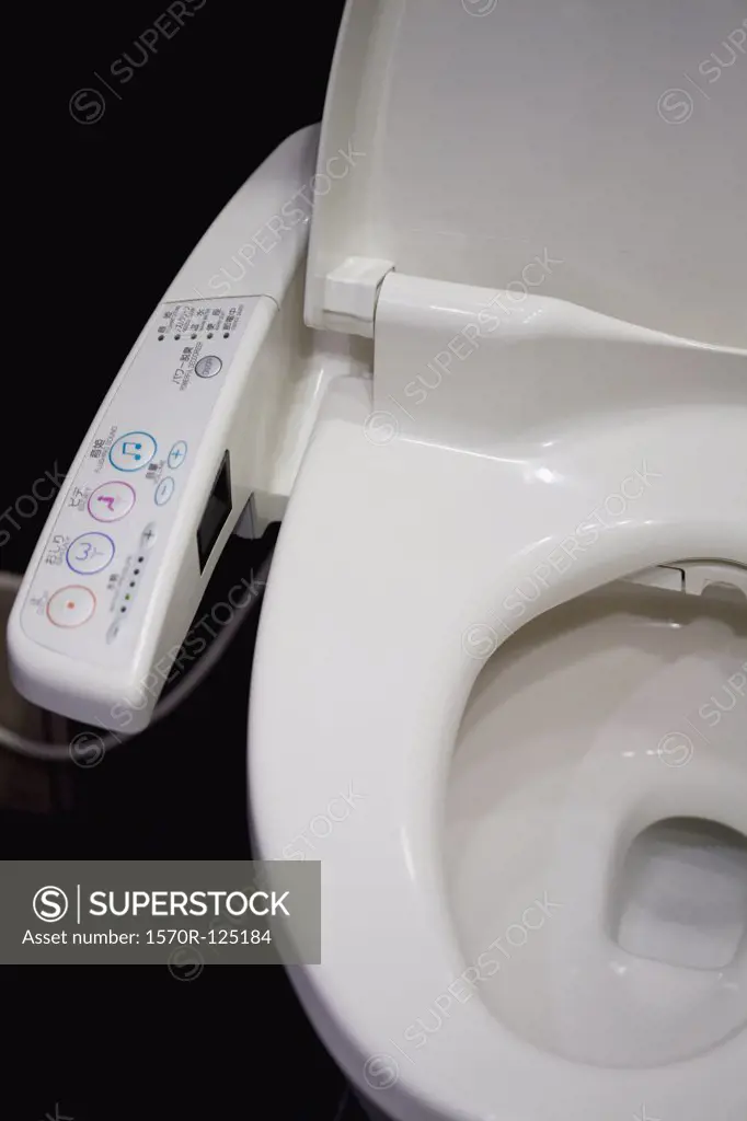 A toilet with remote control on armrest
