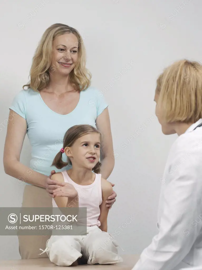 A mother and daughter at medical exam with a pediatrician
