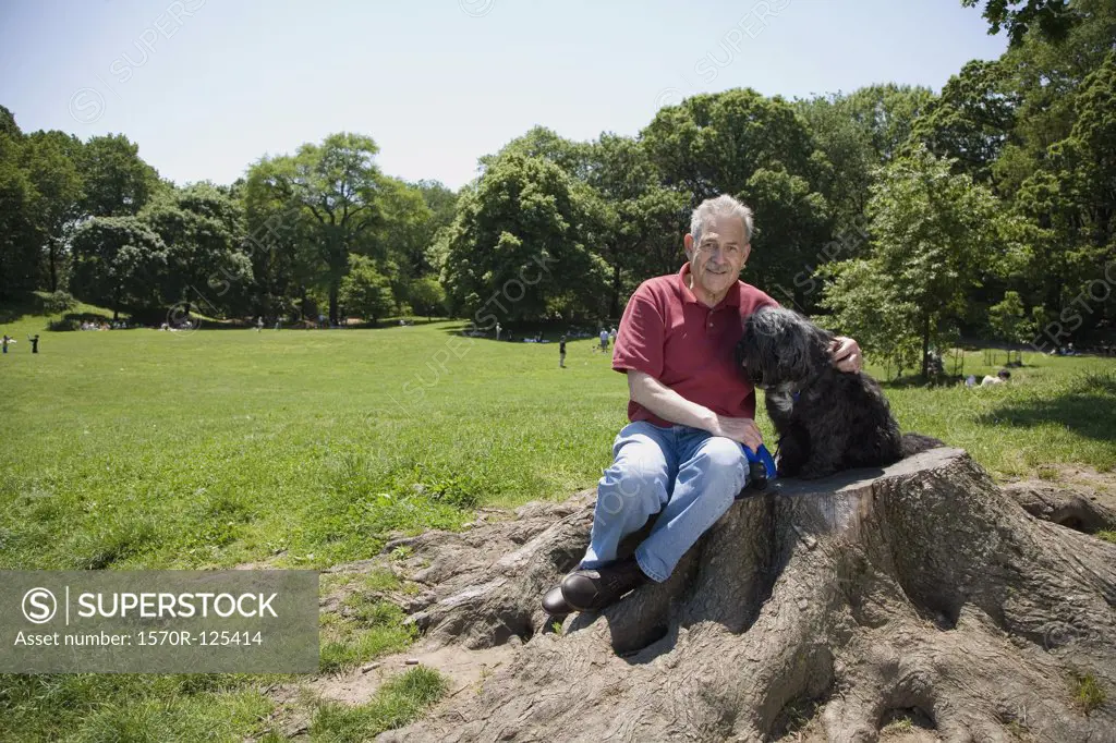 A man sitting with his dog in a park, Prospect Park, Brooklyn, New York, USA