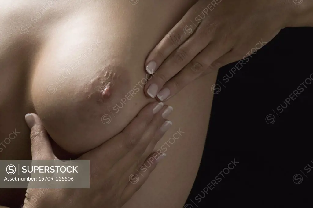 A woman examining her breast