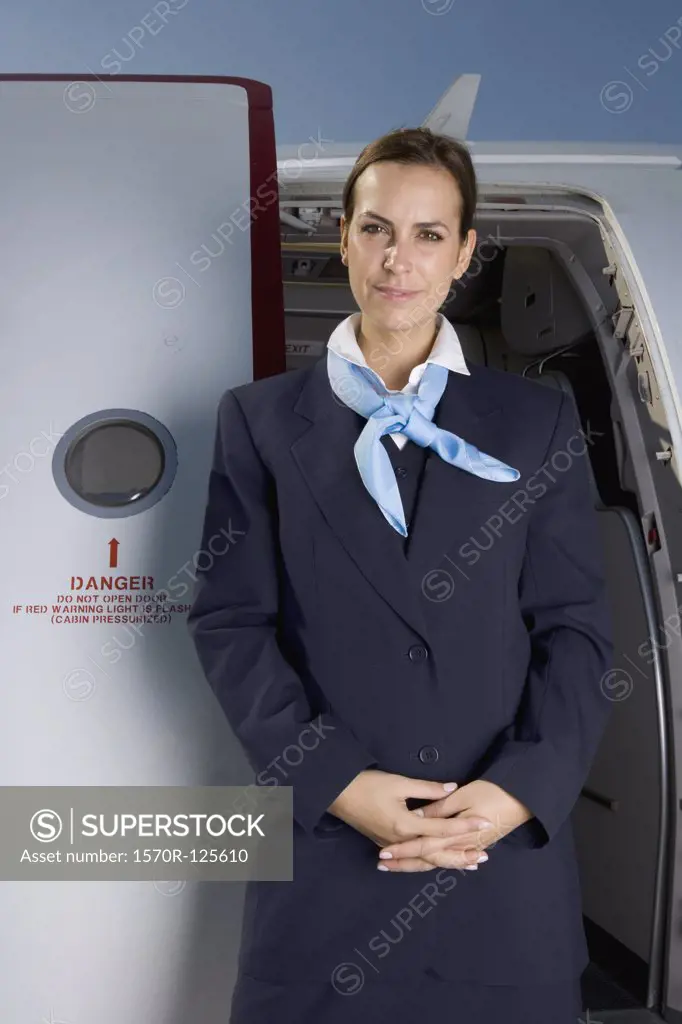 A flight attendant standing in front of a plane door