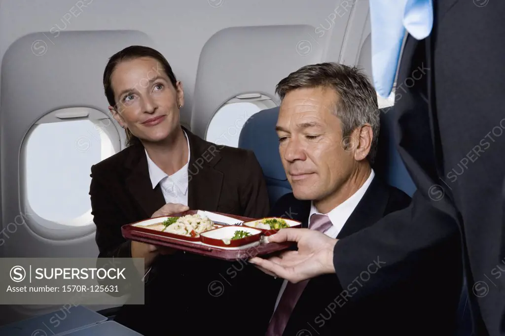 Business people on a plane being served airline food