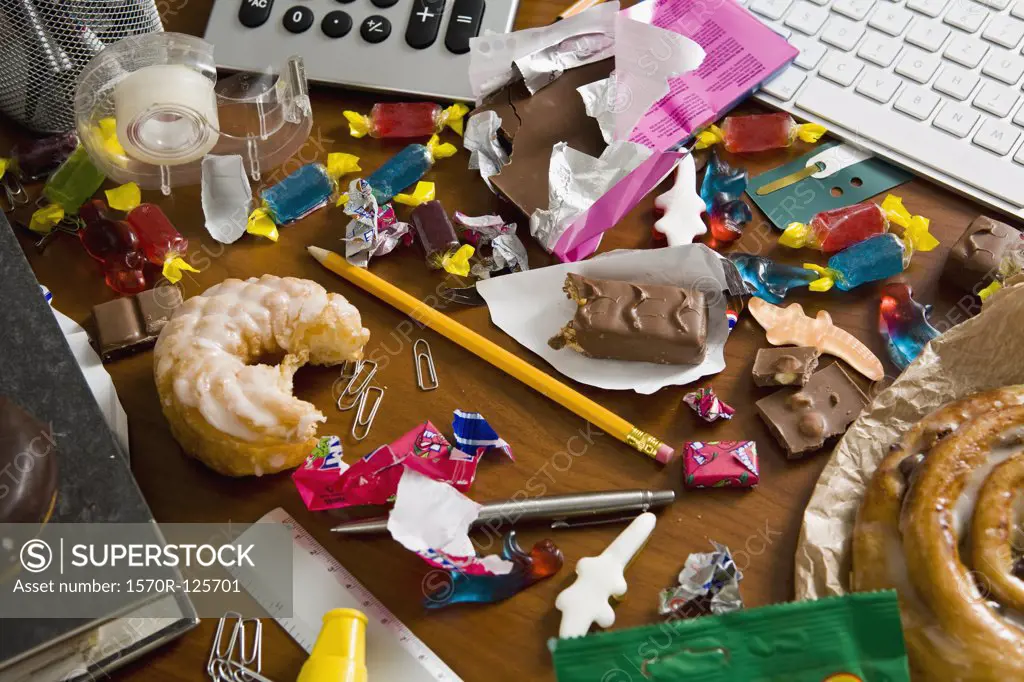 An office desk cluttered with candy and sweets